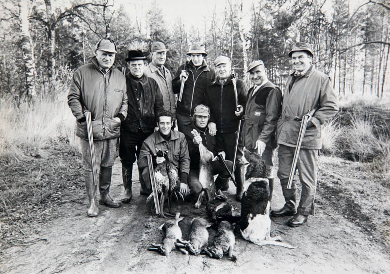 Hennie Kuiper goes hunting in the woods near Esbeek on November 19, 1978, in illustrious company. He immediately shoots a pheasant. Back row from left to right: football referee Leo Horn, the so-called 'Jagermeester', 'Le Fou Pédalant' Gerrit Schulte, Olympic silver clay pigeon shooter Eric Swinkels, the beater, 'My heart stood still, but my Pontiac ran' Wim van Est, and Frisol boss Nico de Vries. In front: rider Tony Houbrechts and Hennie Kuiper. Clay pigeon shooter Eric Swinkels finished second at the 1976 Montreal Olympics. He talks about shooter Kuiper: 'A few weeks ago, Hennie Kuiper came to my shop to buy a gun for hunting. I told him, come with me and let's see first if you can shoot well. He did, and I was totally amazed by the performances Hennie delivered. Out of fifty targets (clay pigeons), he hit 47 in the very first series. I told Hennie, hey, if you really start training in this sport, you can become world champion again.'