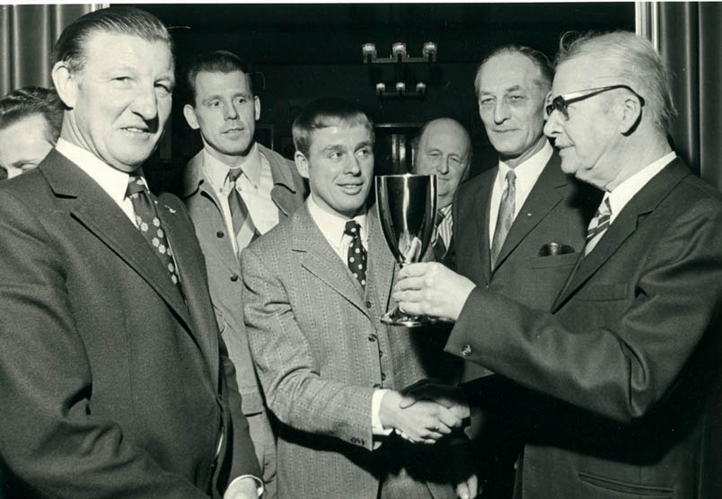 1972 As a rider of the future, Hennie Kuiper receives the Toboga Cup from committee chairman Mr. J. Veenhoven. On the left is Gerrit Schulte, the pacer behind the annual cycling awards gala.