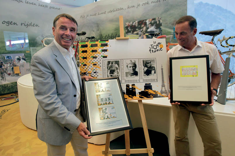 Hennie Kuiper in a completely different role: as an entertainer. During the presentation of special stamps on the occasion of the Grand Départ of the Tour de France in 2010 from Rotterdam, Kuiper unveils a framed stamp booklet featuring 'Dutch cycling successes'. Bernard Hinault displays the PTT Post stamps with the Grand Départ design.