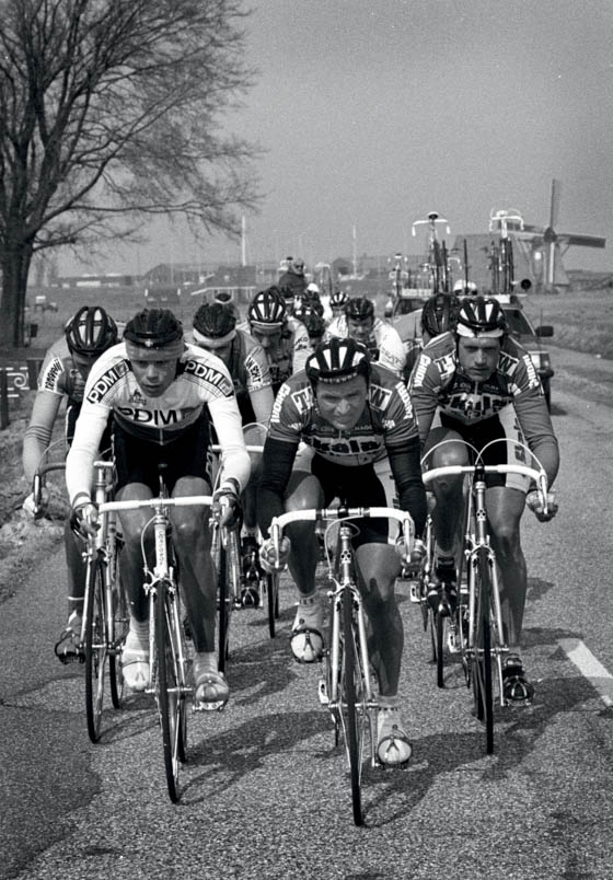 Hennie Kuiper tijdens de derde Profronde van Friesland tussen links Gert-Jan Theunisse en rechts ploeggenoot Adri van Houwelingen. De wind houdt zich stil wat de koers weinig selectief maakt. Hans Daams wint in Joure. Hennie Kuiper fietst keurig bij de eerste zeven