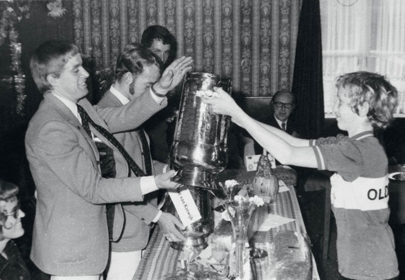 At the reception that accompanies the Olympic performances, Hennie Kuiper, Piet van Katwijk, and Fedor den Hertog are showered with gifts. Here, the riders receive a copper kettle from the cycling youth of OWC from Oldenzaal.