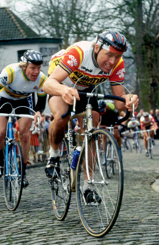 Hennie Kuiper worstelt zich op de Muur van Geraardsbergen in Vlaanderens Mooiste van 1984 naar boven met Jos Schipper in zijn voetspoor