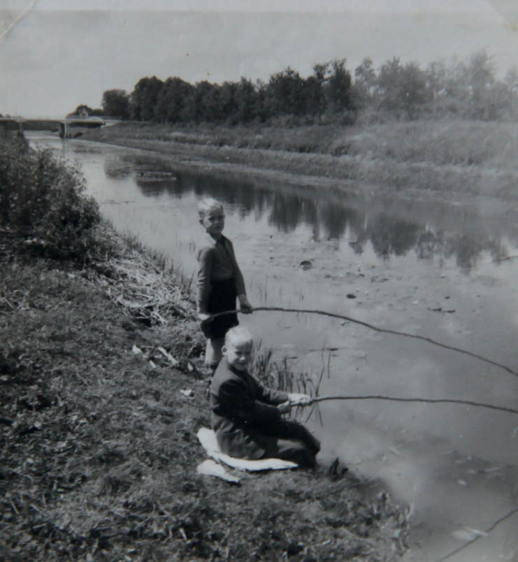 Hennie's brothers Frans and Bennie fish with homemade fishing rods in the Almelo-Nordhorn canal along the Schotbroekweg. Here, along this canal, cyclist Hennie Kuiper was born.