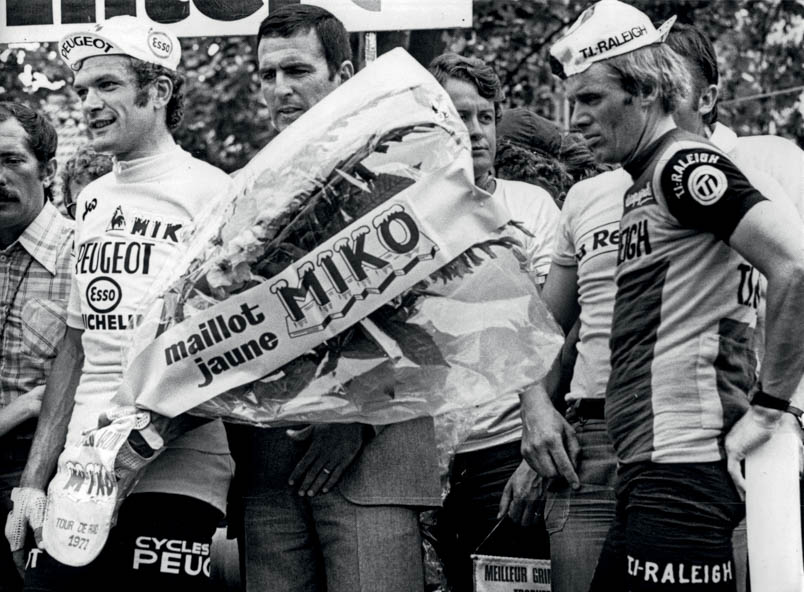 Niemand hoeft ervoor doorgeleerd te hebben om op het podium in Parijs het chagrijn van Hennie Kuiper te onderkennen. Bernard Thévenet wordt links door de sponsors gefêteerd, Hennie Kuiper heeft zwaar de pest in