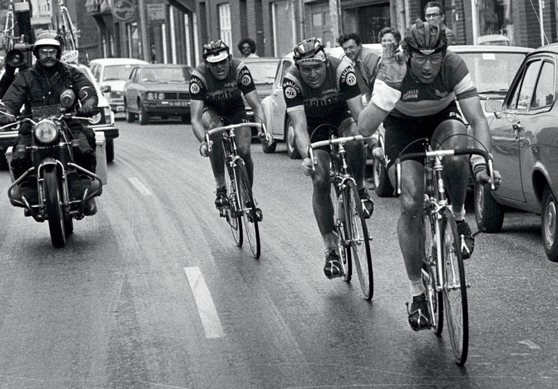 De spanning loopt op in de slotkilometers van de Amstel Gold Race. Raas probeert met handgebaren de motard van fotograaf Tonny Strouken op veilige afstand te houden