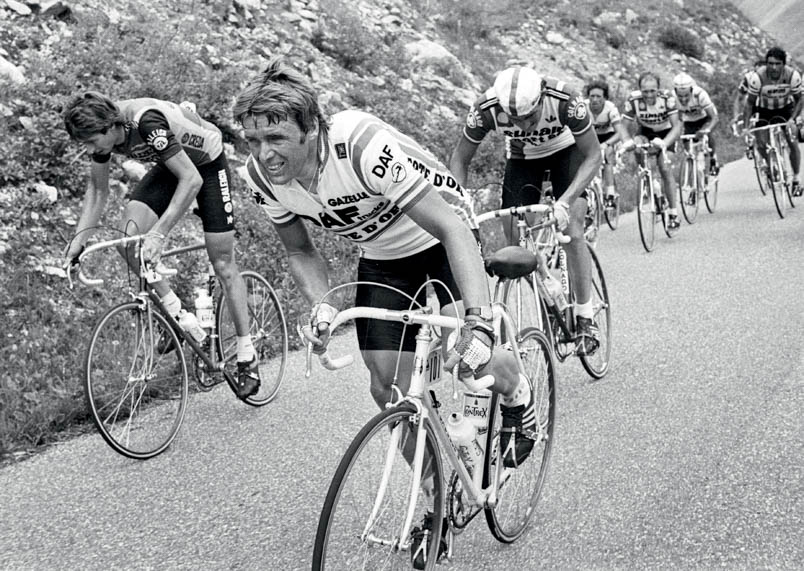 Hennie Kuiper heeft het ook moeilijk op l’Alpe d’Huez. De zege is deze dag voor Peter Winnen. Hennie eindigt in de rit als 25ste. Links van Hennie: Johan van der Velde. In de achtergrond staat Joaquim Agostinho op de pedalen met links van hem Eddy Schepers