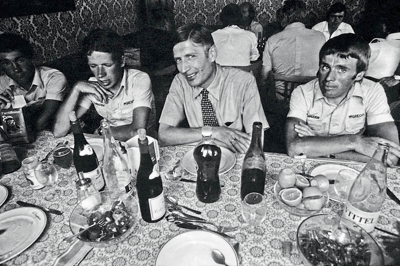 High-profile visit at the Tour de France with the Raleigh team. Between Henk Lubberding and Hennie Kuiper, Prime Minister Dries van Agt joins for a meal, and the KVP leader visibly enjoys it.