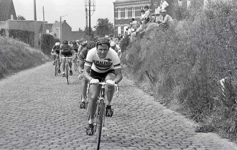 In the fourth stage of the Tour 1976, Hennie Kuiper leads the large group. To the left of Kuiper are Michel Pollentier and Joop Zoetemelk on the lookout.