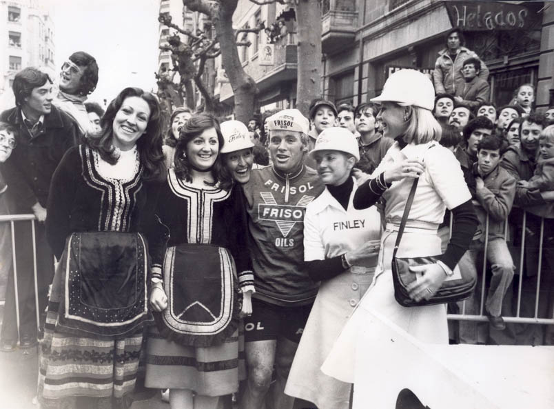 In the cycling-crazy Spain, fans hang on the fences to catch a glimpse of stage winner Hennie Kuiper among the promotional girls.